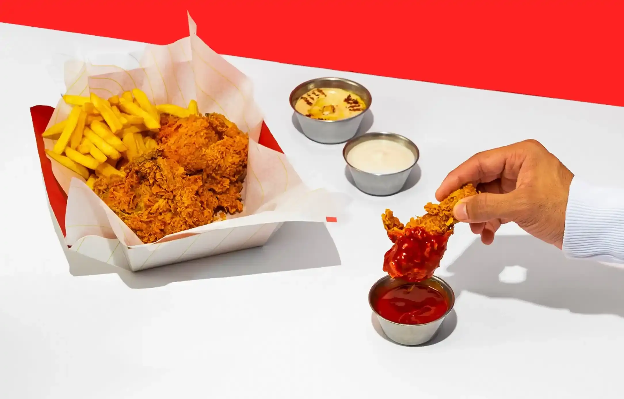 Hot chicken sandwich with fries on a table