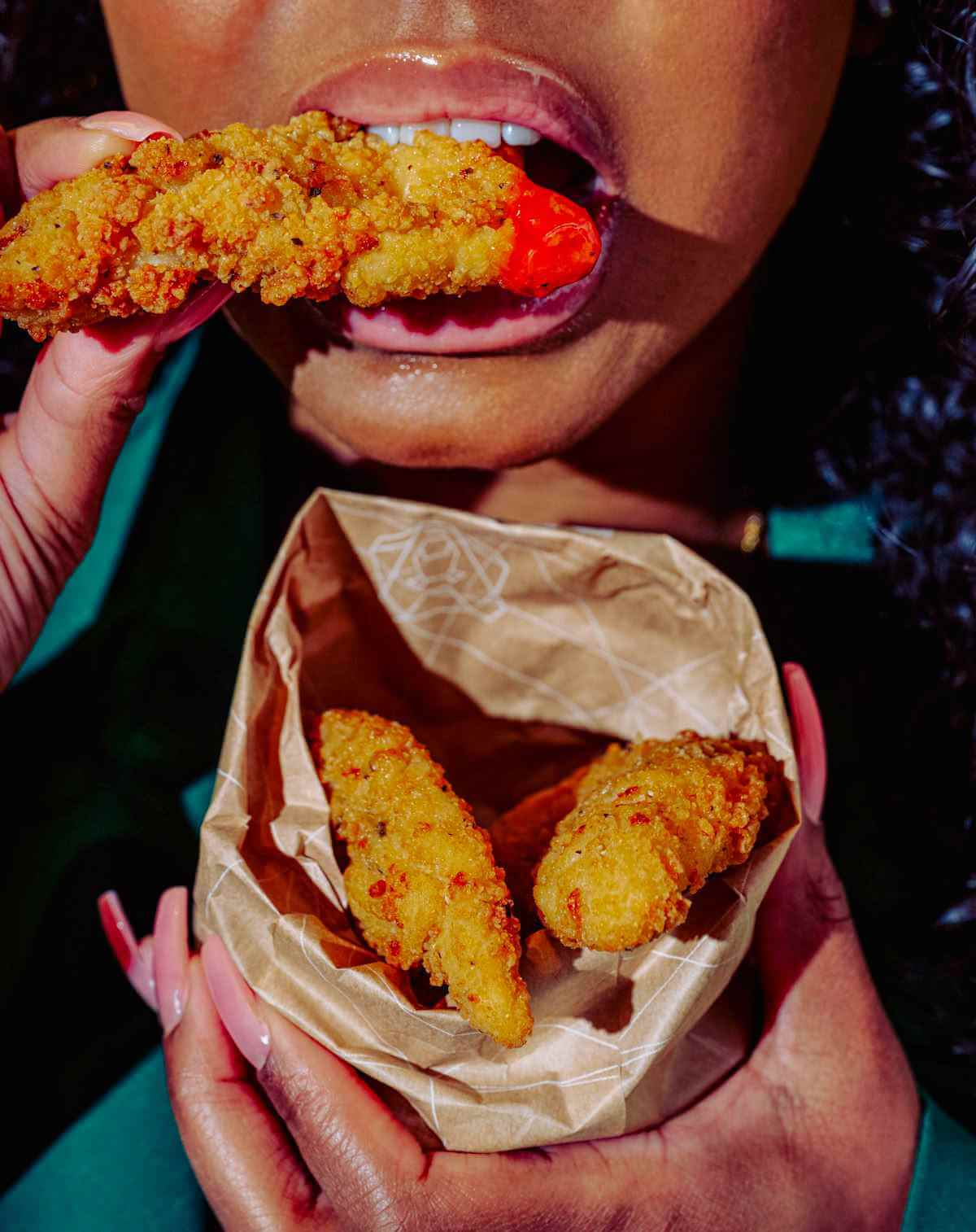 Happy guest holding a spicy chicken burger